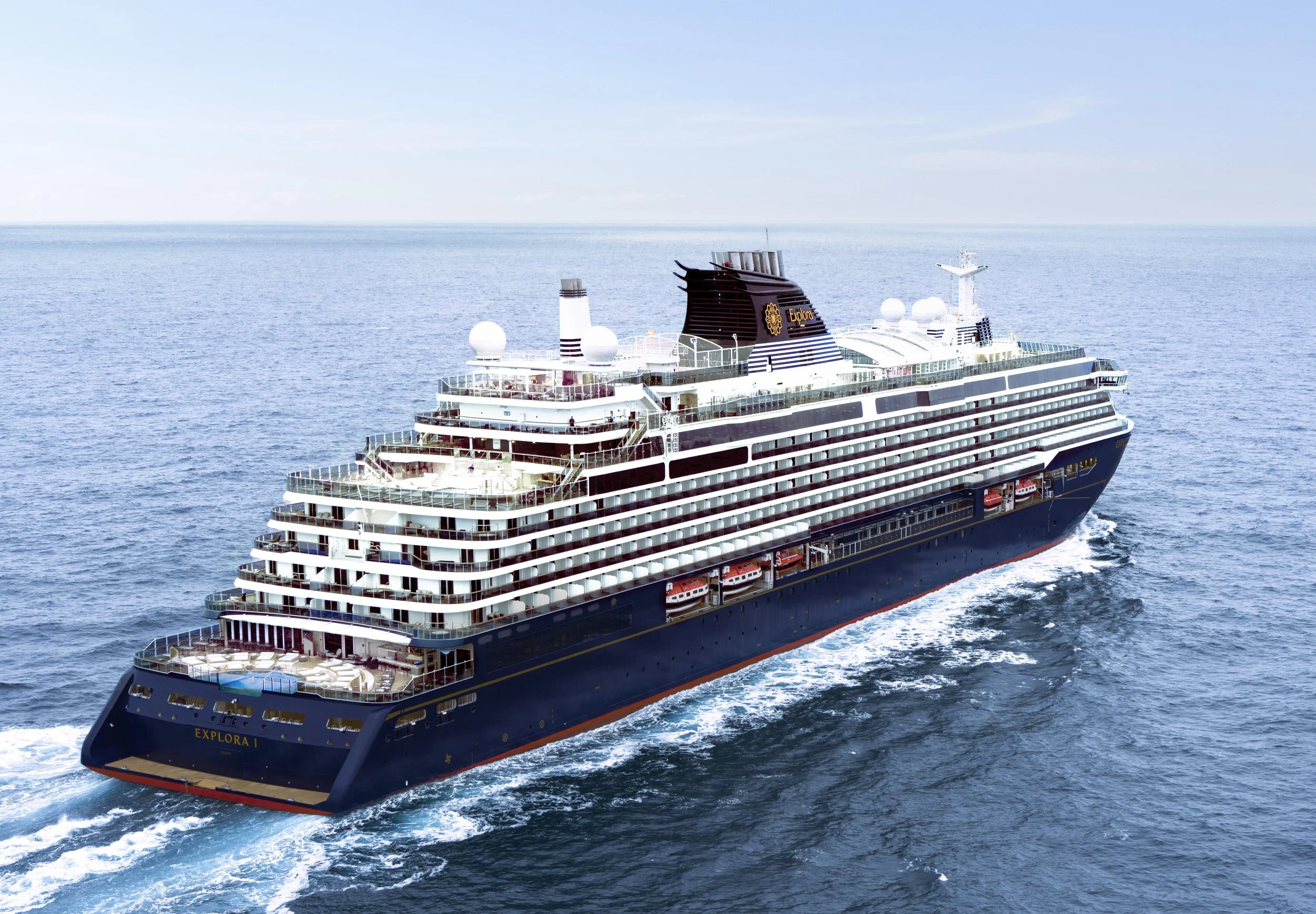 A large cruise ship named Explorer sailing on calm ocean waters under a clear blue sky.