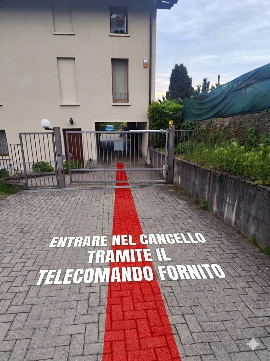 Cancello di ingresso con una linea rossa e testo in italiano che dice: "Entrare nel cancello tramite il telecomando fornito".