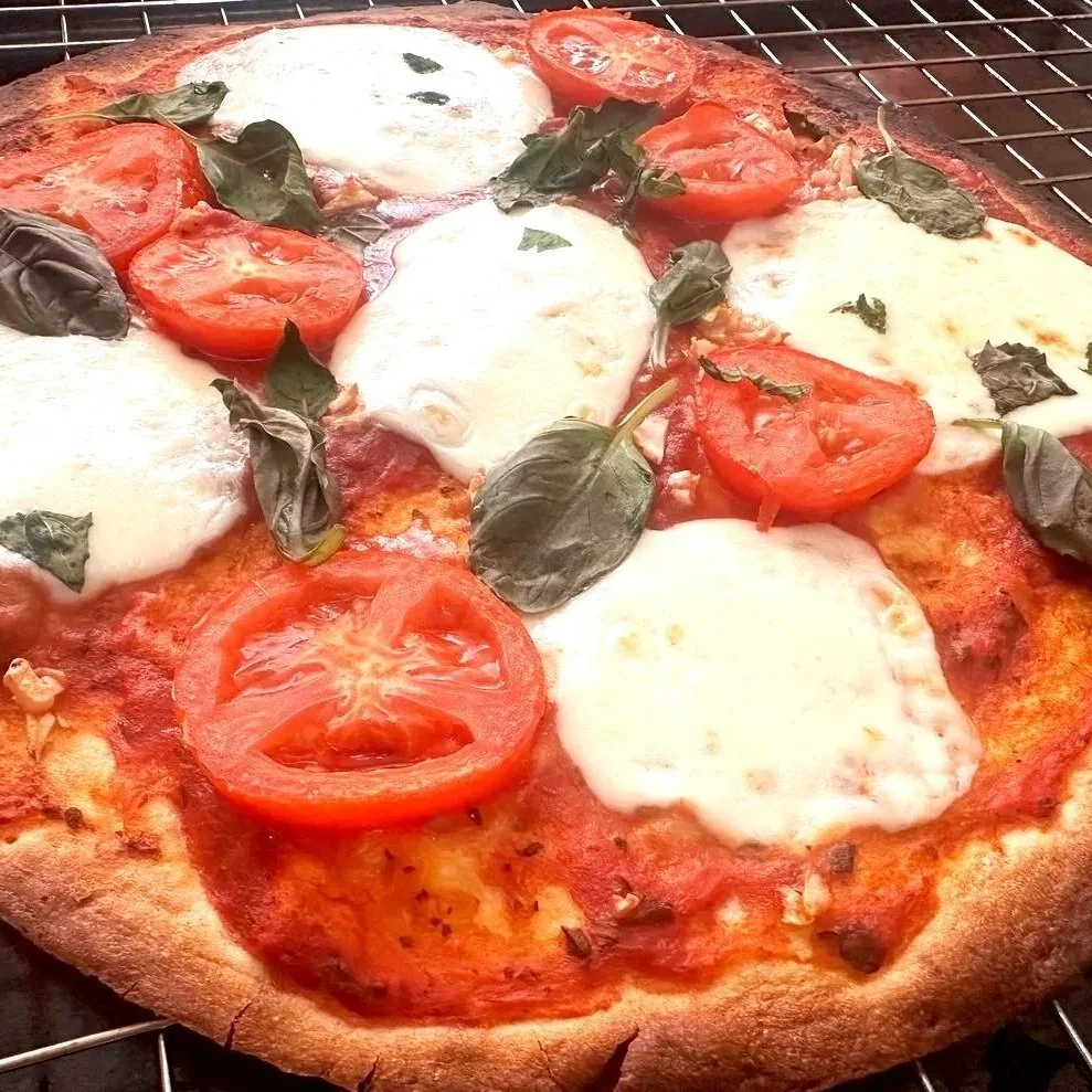 Homemade Margherita Pizza — Fresh tomatoes, mozzarella, basil, and a homemade crust.