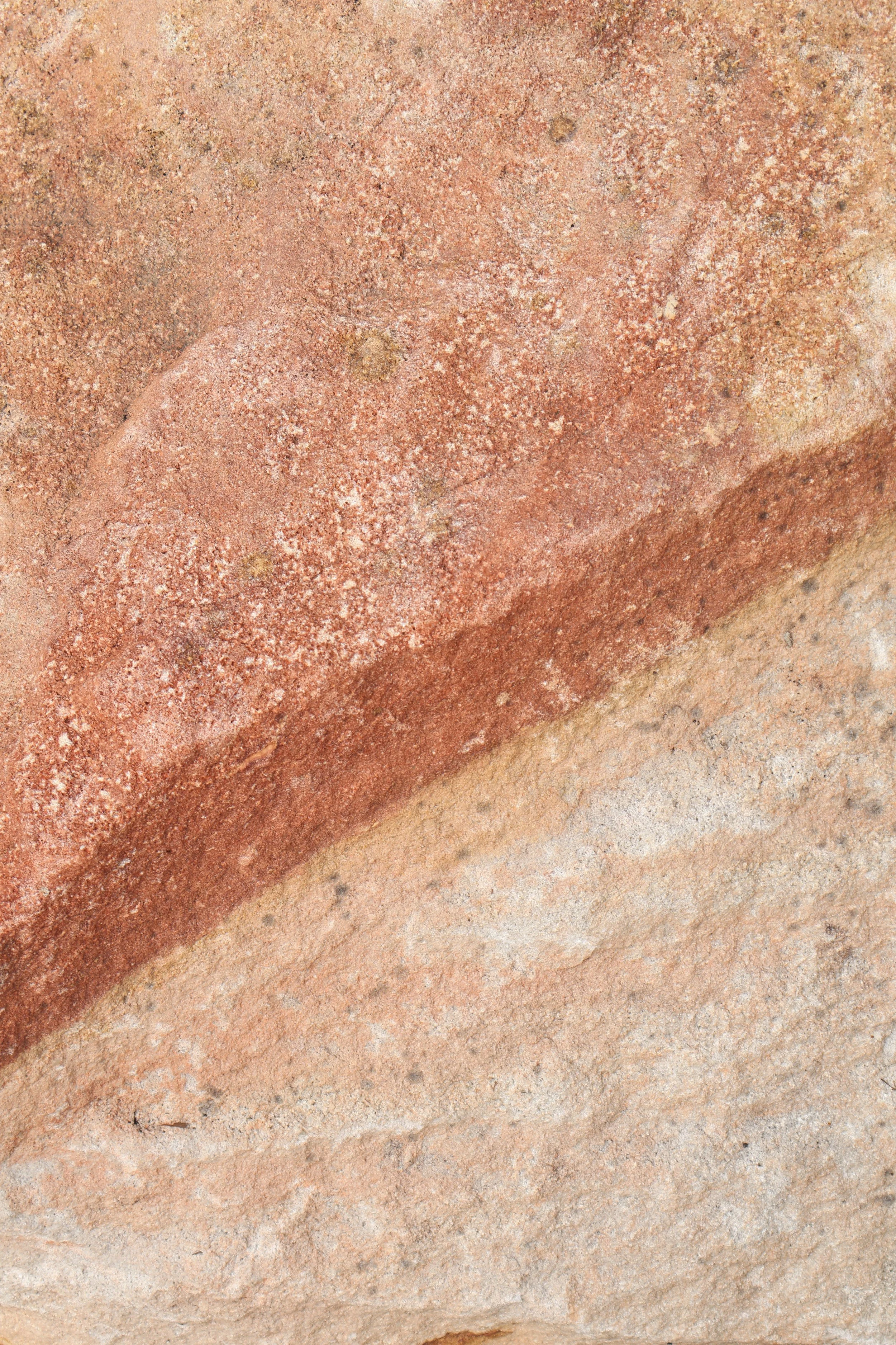 Close-up of a textured clay brick with reddish and tan hues.