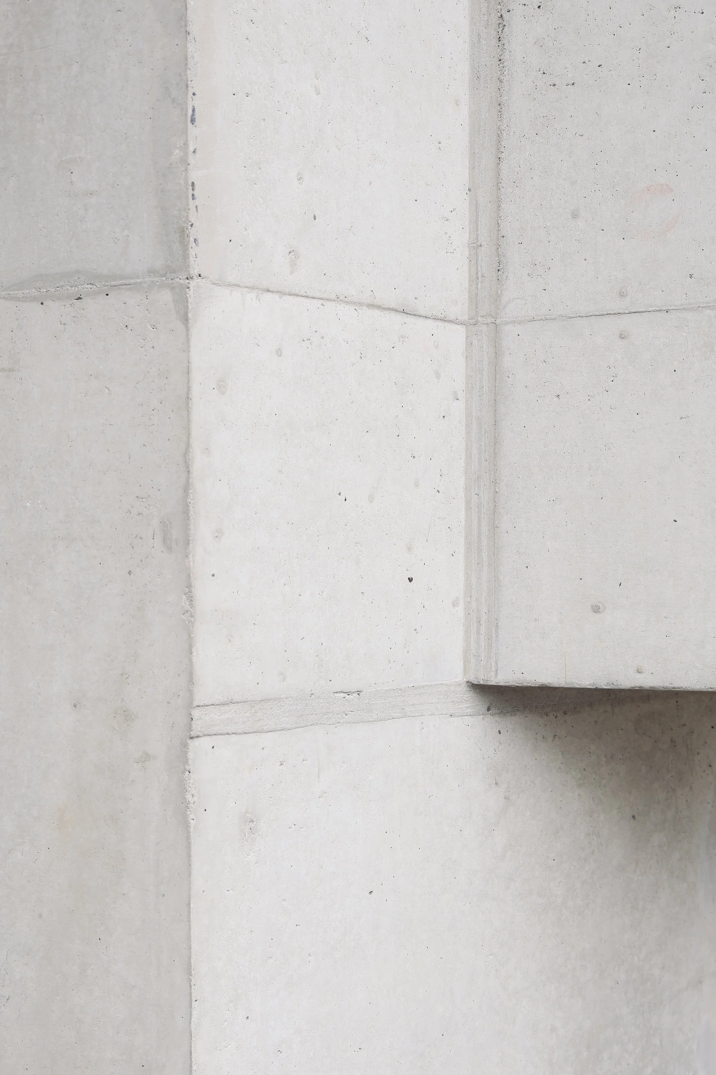Close-up of a concrete wall corner with visible joints and textures.