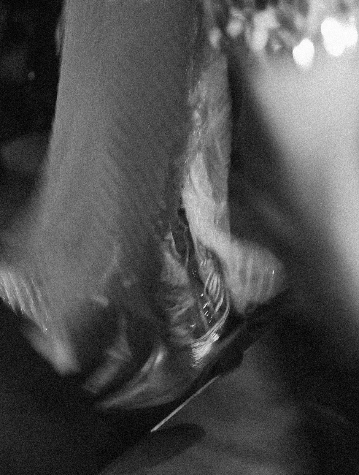 A close-up black and white image showing a glass of water being poured, with some splashes visible.