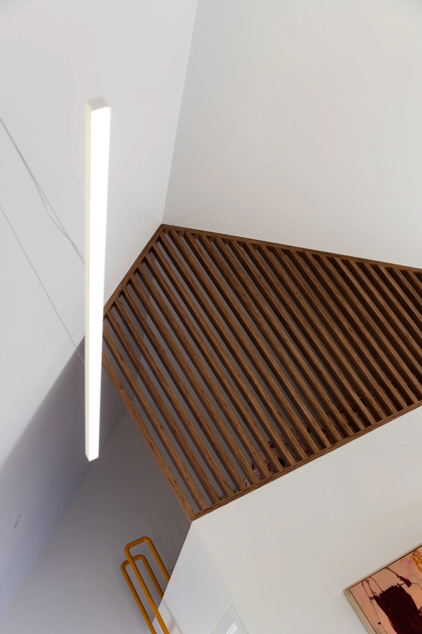 Ceiling with a wooden slatted architectural feature and modern lighting in a contemporary interior.