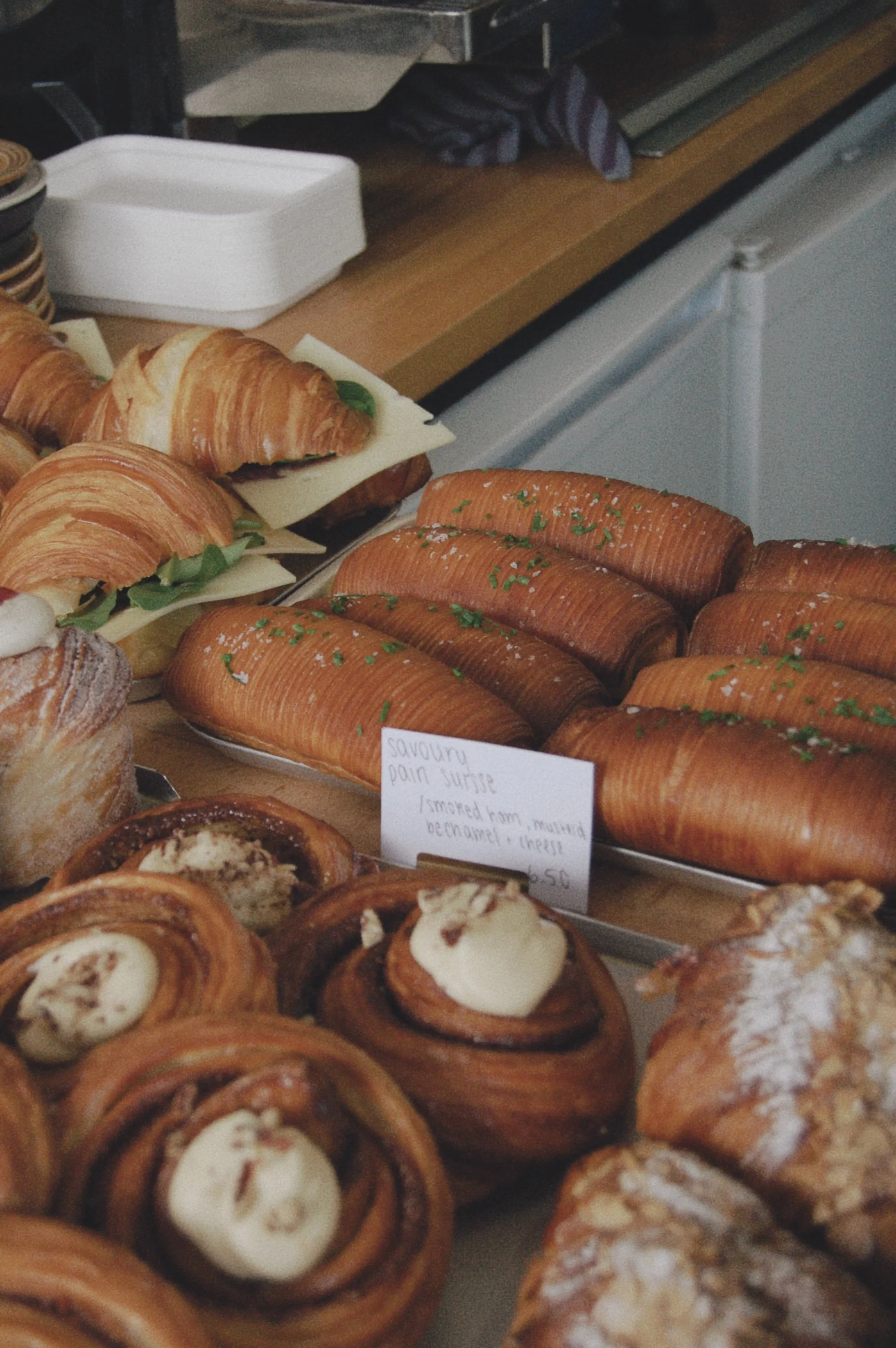 Assorted baked goods including croissants, danishes, and pastries displayed at a bakery.
