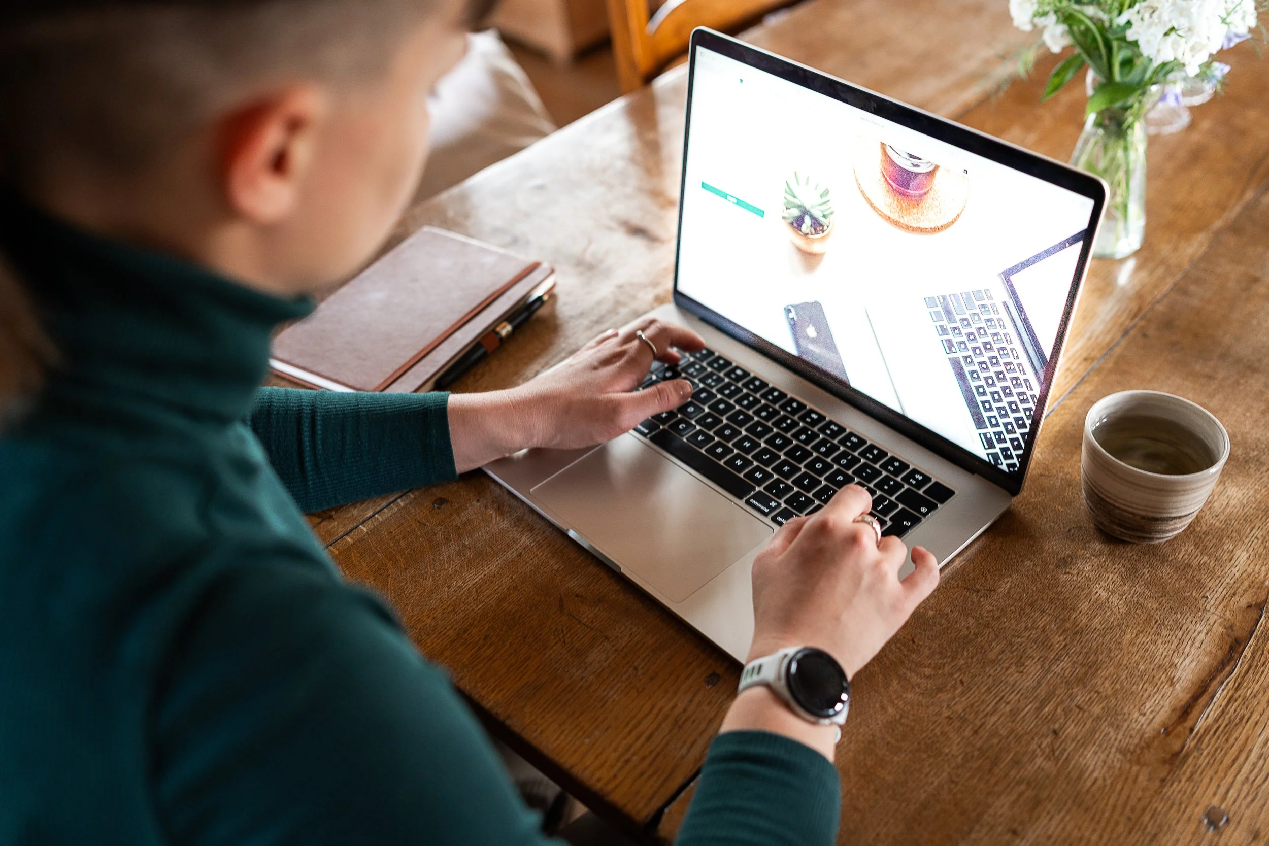 Therapist working online, with a notebook and pen beside them.