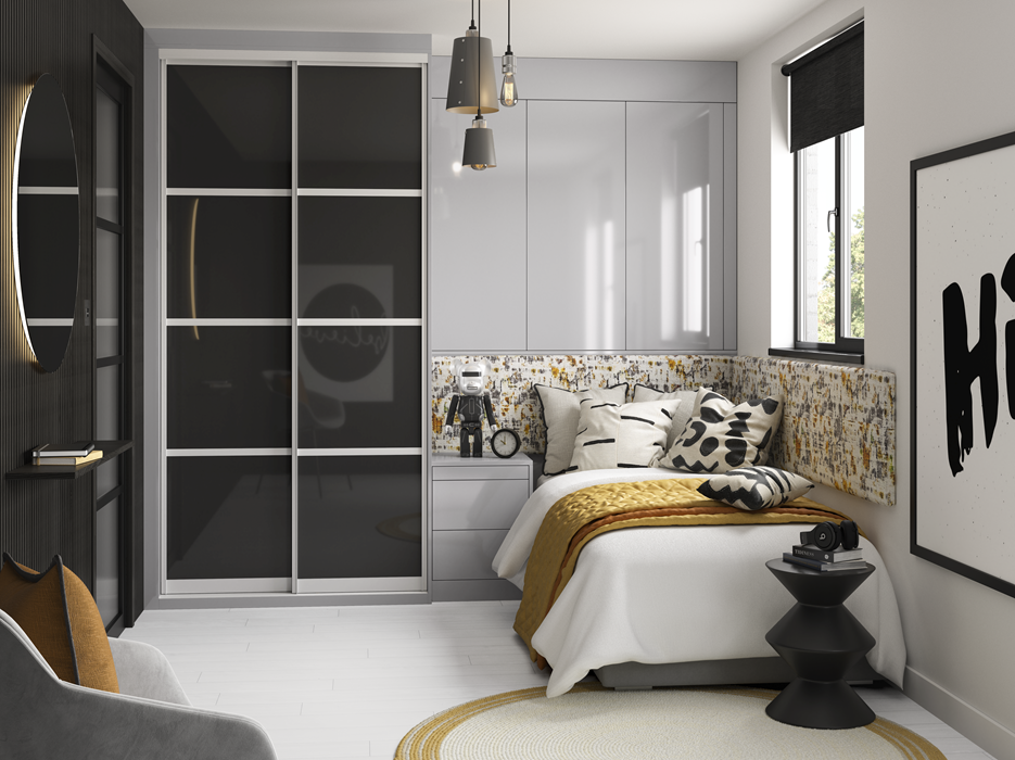 Modern bedroom with gray walls, a white bed with black and white pillows, mustard blanket, and a floral headboard. There is a black side table with headphones and a book, large window with black blinds, and contemporary lighting fixtures. Decor inclu