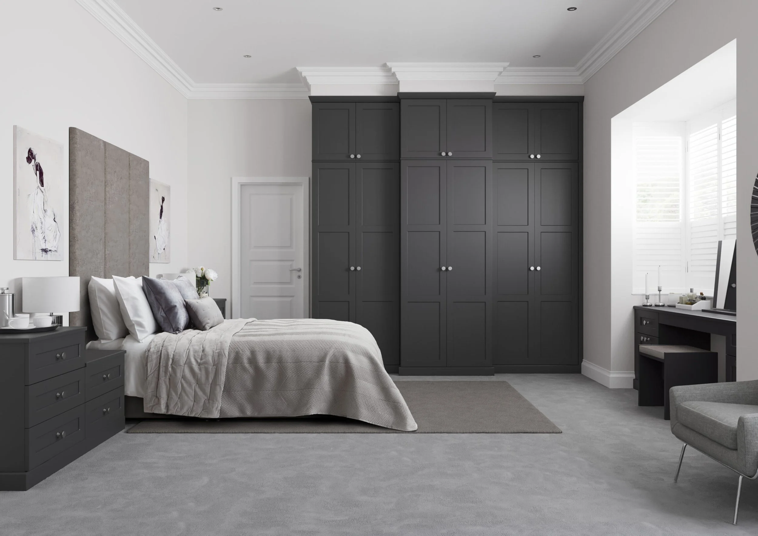 A modern bedroom with a bed, nightstands, dark gray built-in closet, and a gray armchair near a window with white shutters.