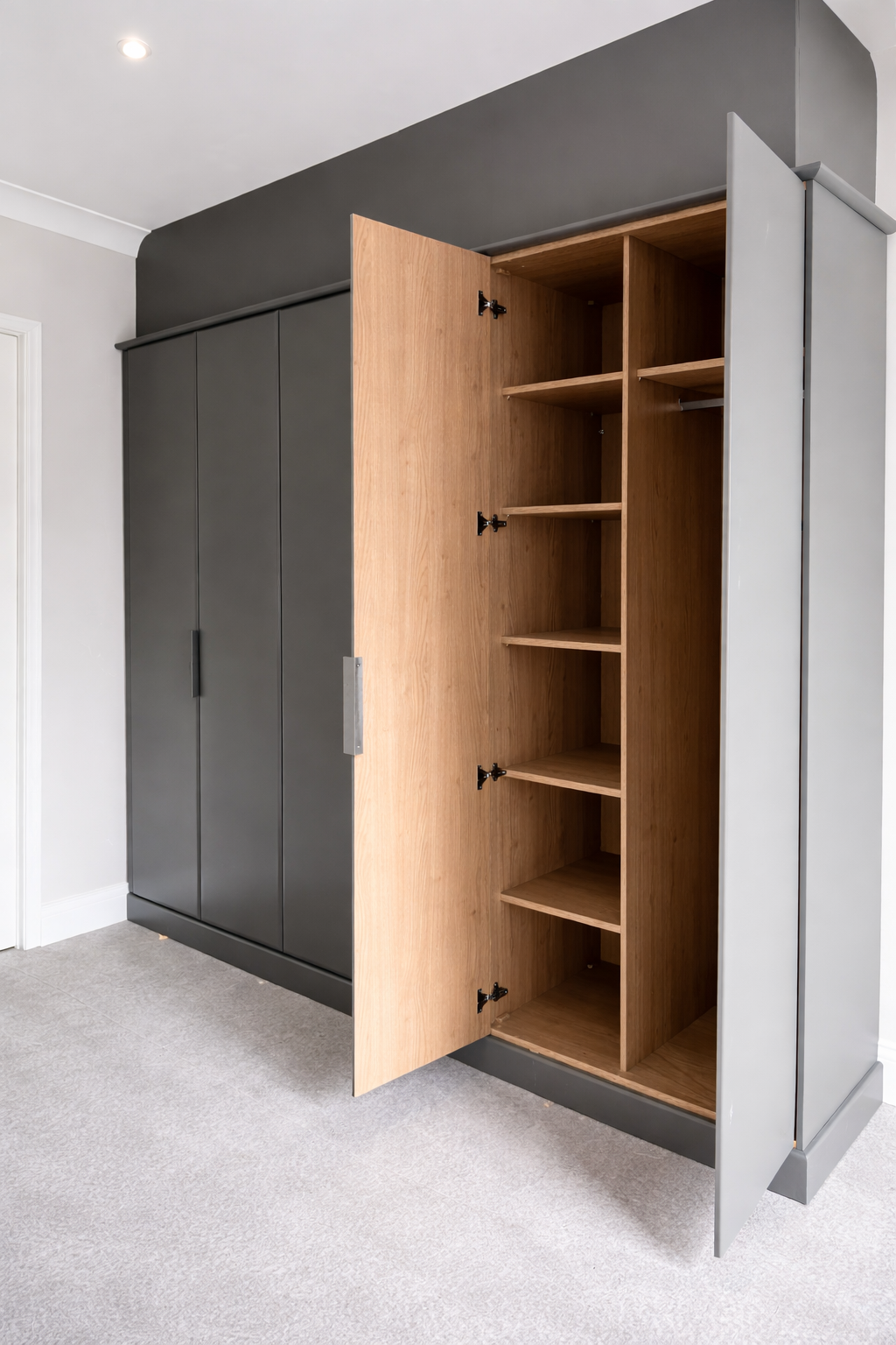 Modern wardrobe with gray exterior doors and open wooden interior shelves, standing in a room with white walls and light gray carpet.