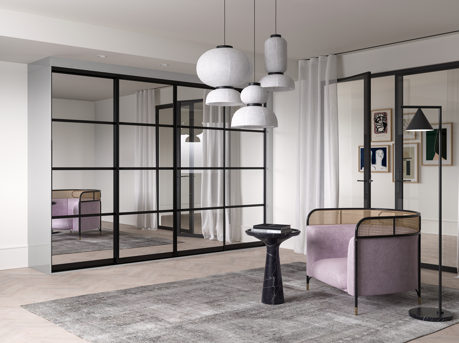 Modern living room with glass partition, pastel pink armchair, black side table, abstract art wall decor, and hanging pendant lights.