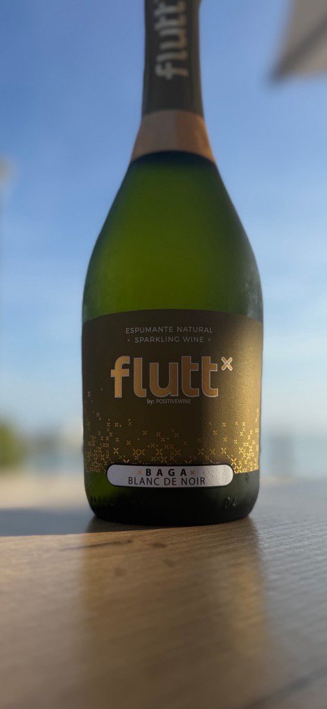The dark green glass bottle features a prominent dark label that reads *flutt* with the subtitle ESPUMANTE NATURAL