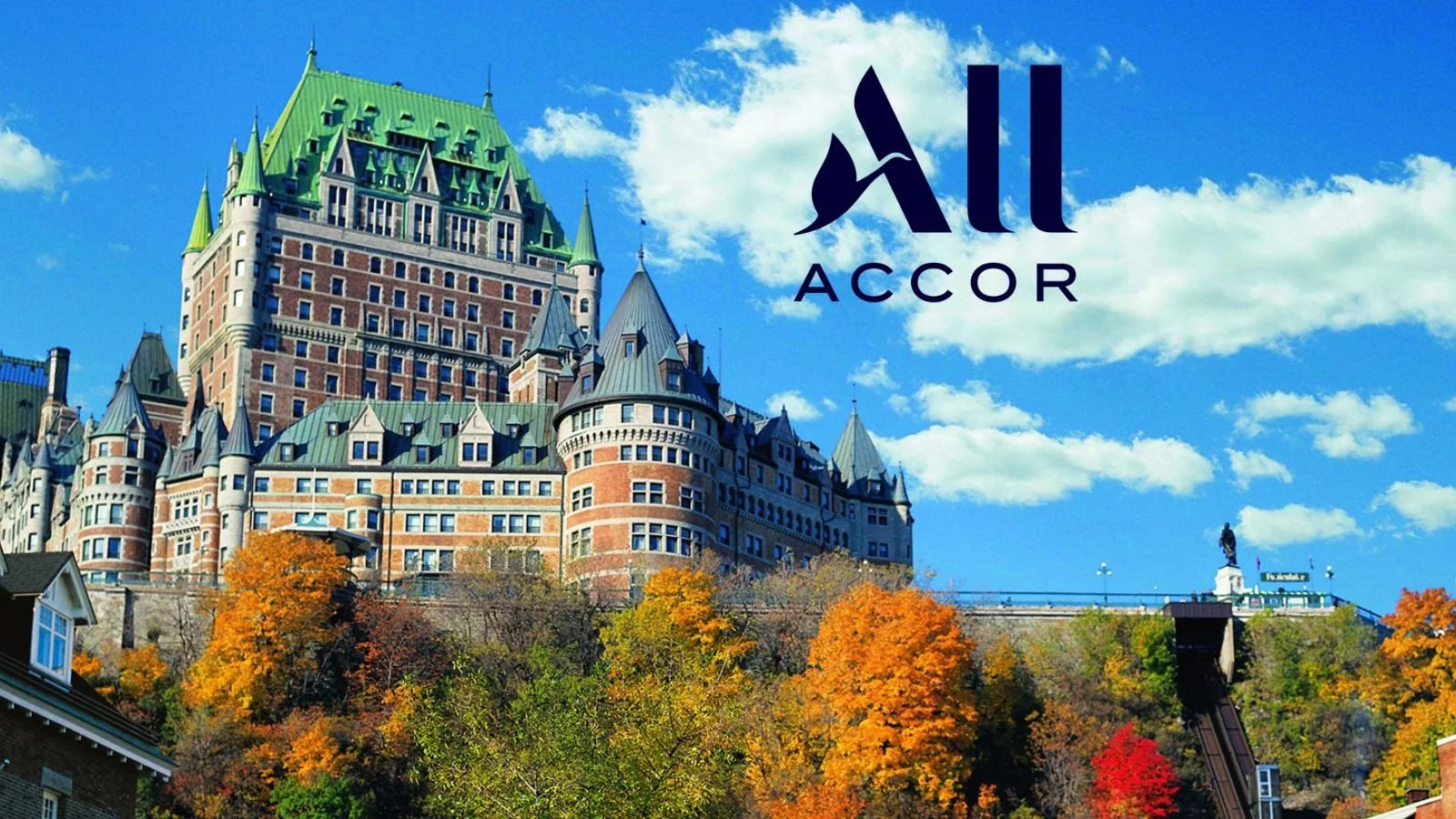The Fairmont Le Château Frontenac hotel on a hill, with fall trees and a blue sky with clouds. The All Accor logo is in the top right corner.