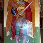 Colorful painted figure of a warrior holding a sword, dressed in traditional clothing, set against a vibrant background.