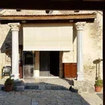 Facade of a building with stone columns and entrance door, outdoor street scene