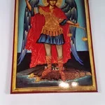 Icon of a saint dressed in ornate red and gold robes, holding a scepter and a cross, with a halo around his head.