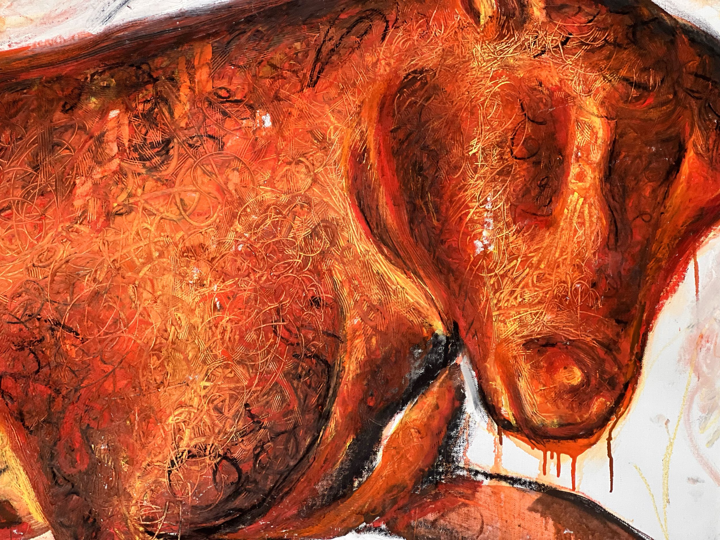 Close-up of an abstract painting featuring warm colors like red, orange, and black with chaotic swirling lines and textured brushstrokes.
