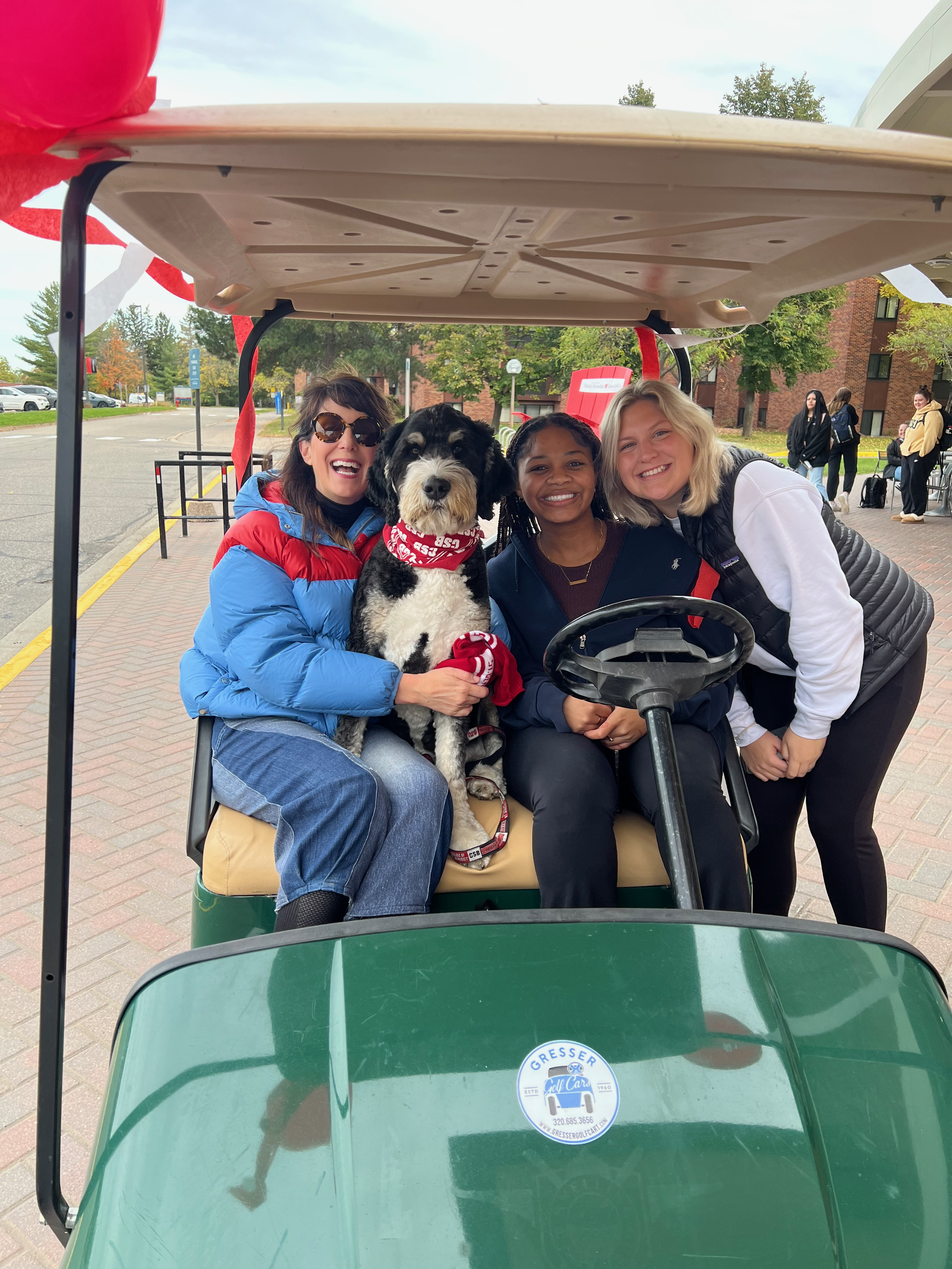 George and Carol Bruess with 2 students on a golf cart
