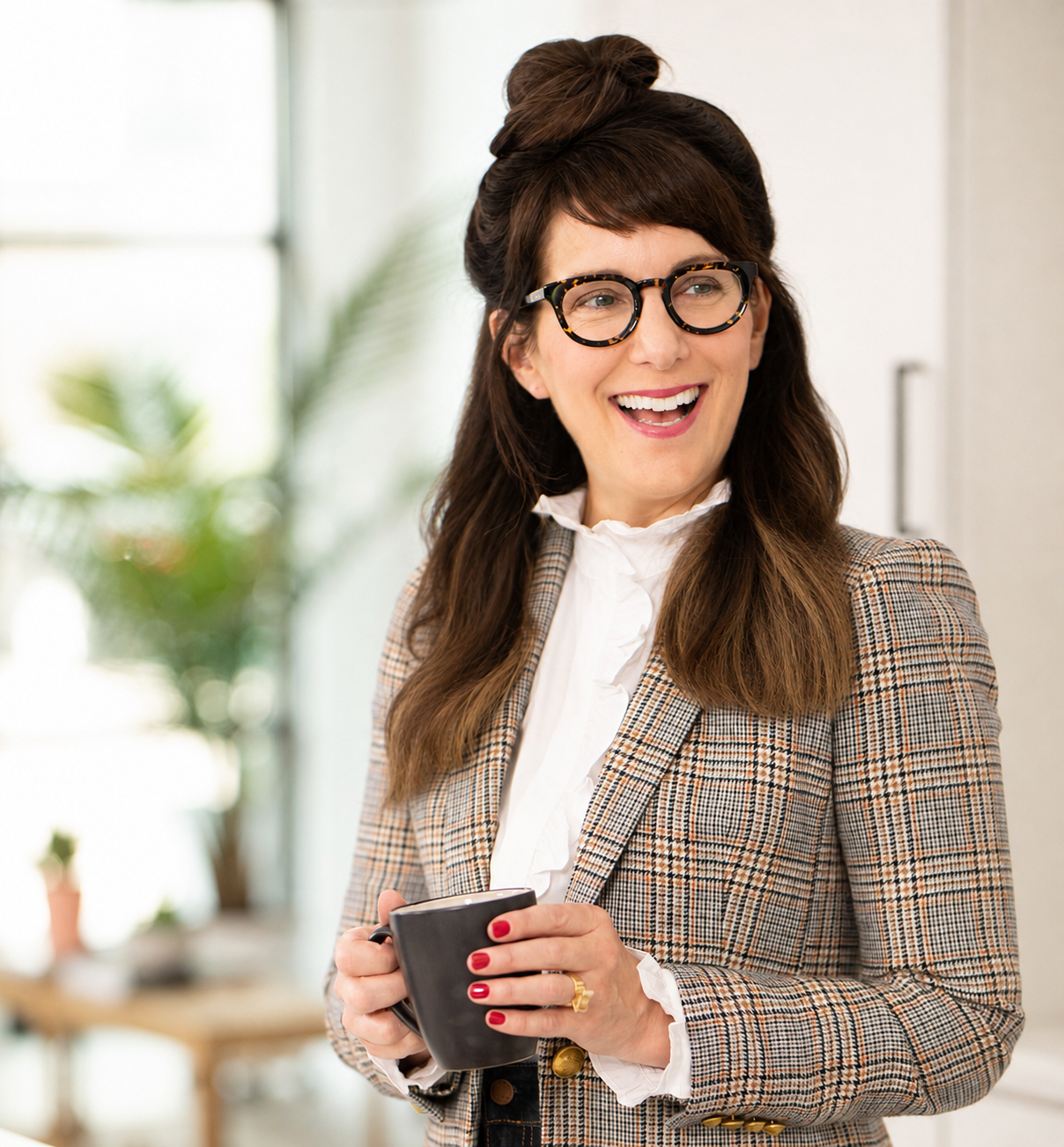 Carol Bruess holding a mug with a large smile
