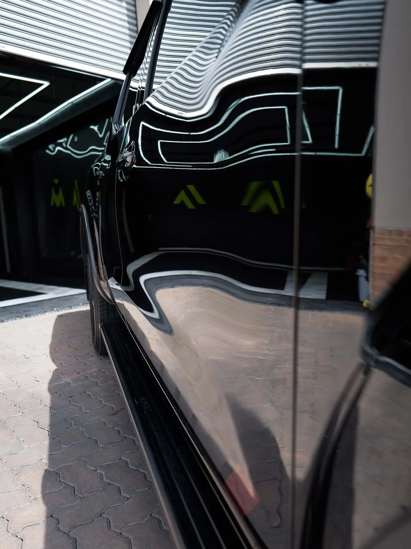 Innovation Auto logo mirrored in the ceramic-coated panel of a black car