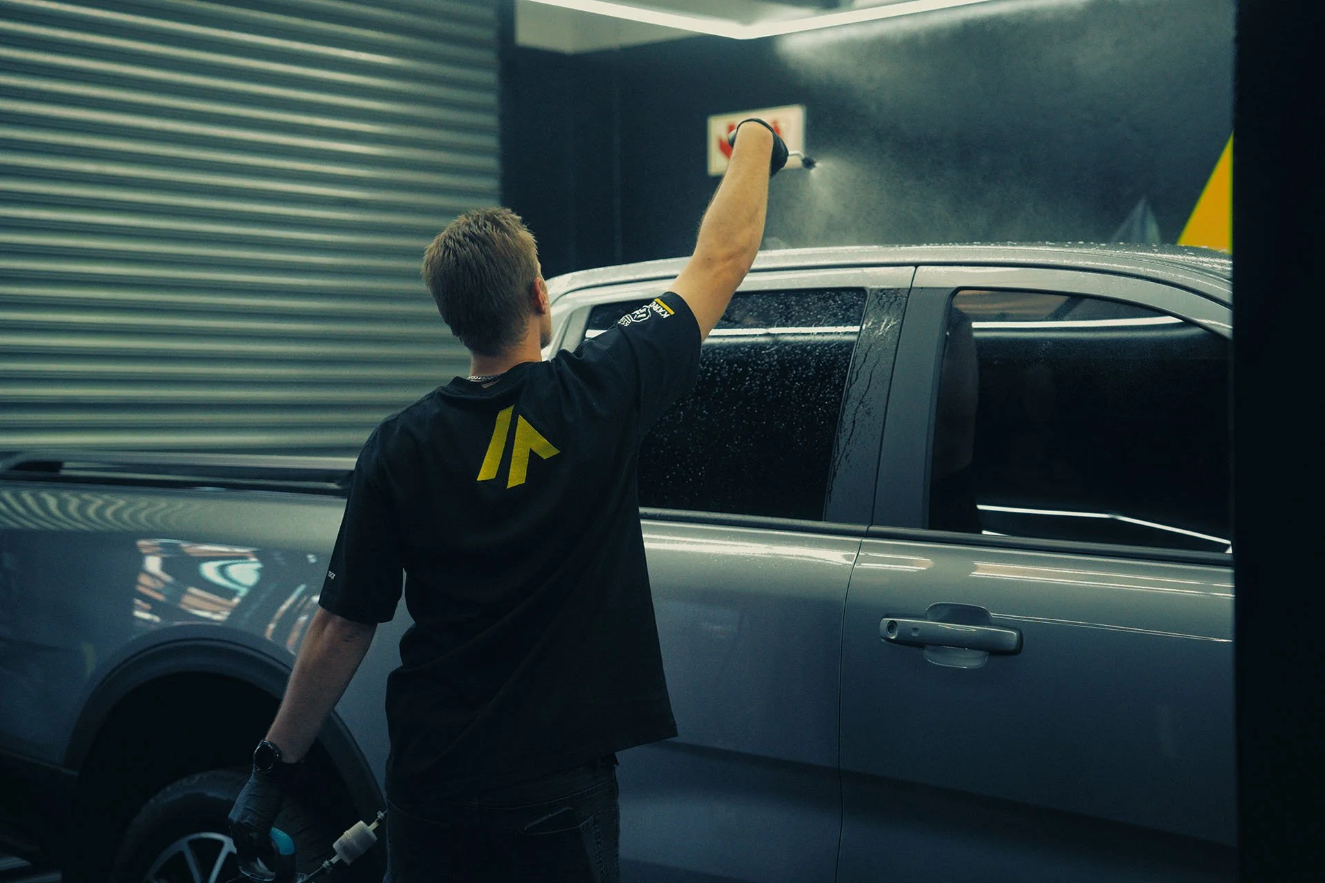 Installer applying paint protection film along a Ford Ranger's window