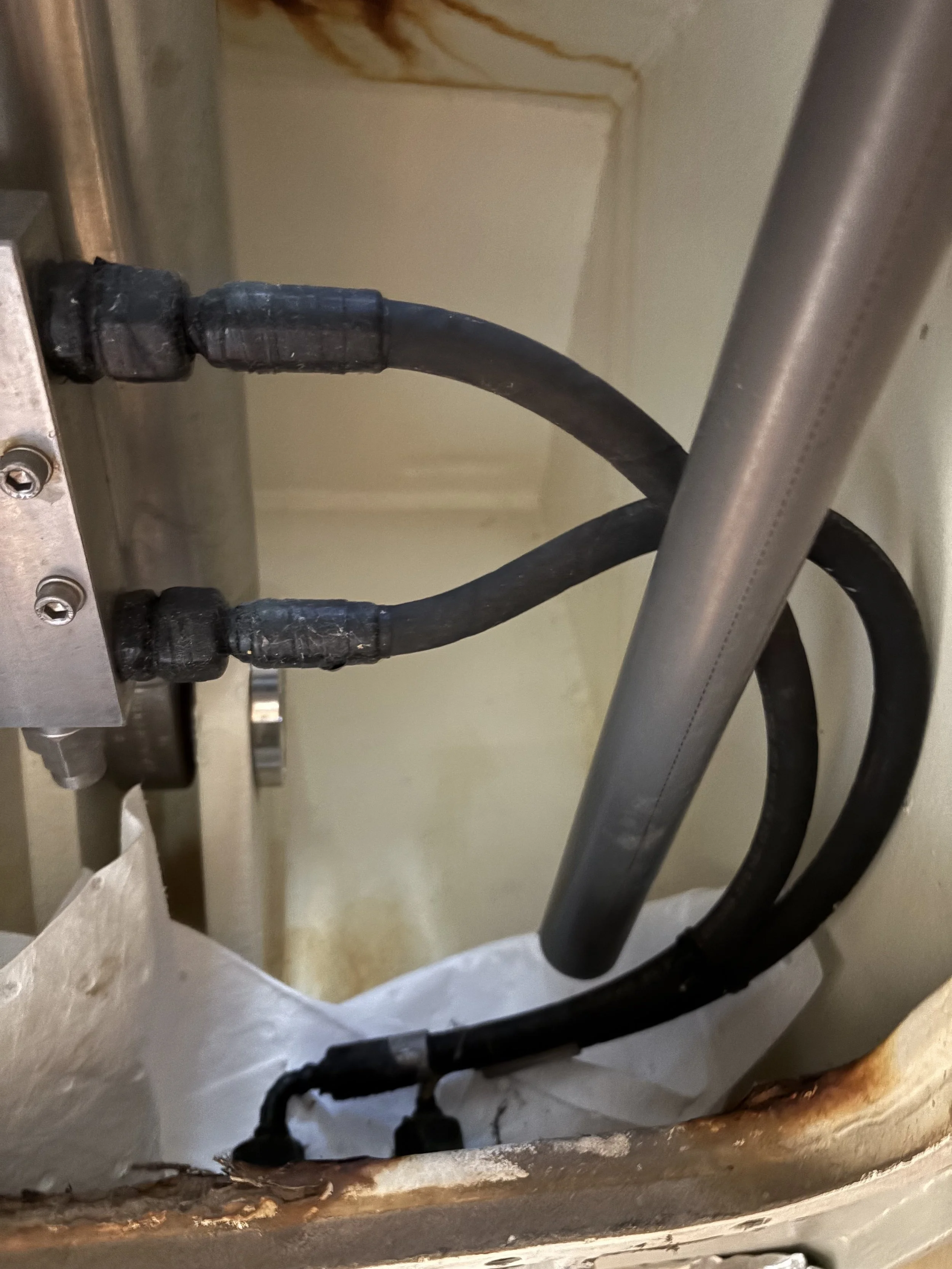 A close-up view of 2 hydraulic hoses that require replacment.