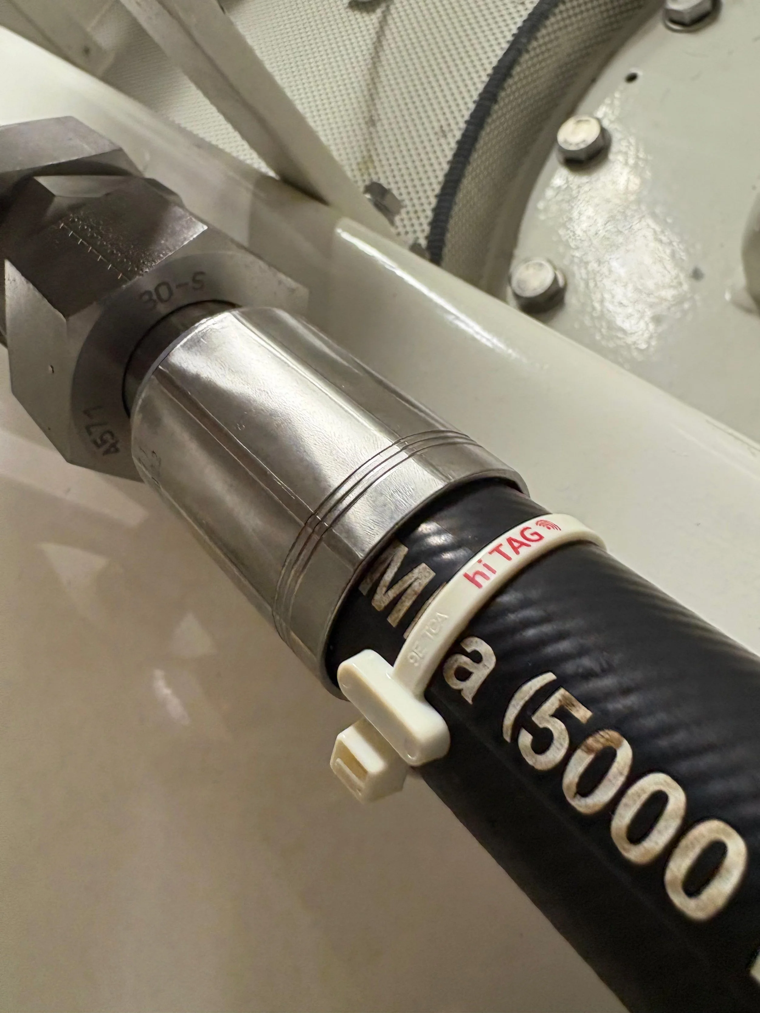 Close-up of a 30-S metric hydraulic hose, labeled with our hose management tag. Ready to be scanned and replaced at any moment.