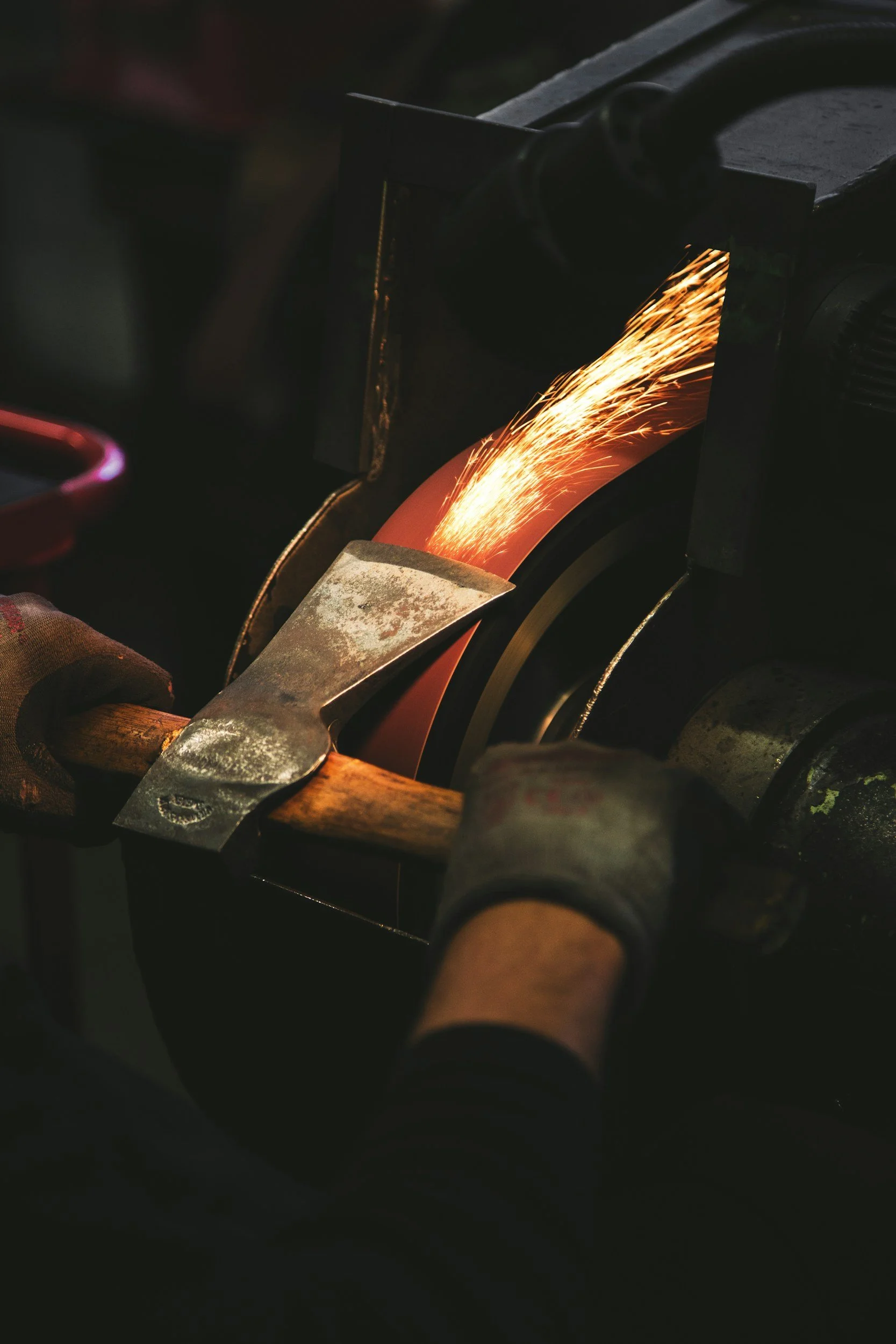 Un artisan utilise une scie pour couper un matériau en ébullition, avec des étincelles produites durant la coupe.