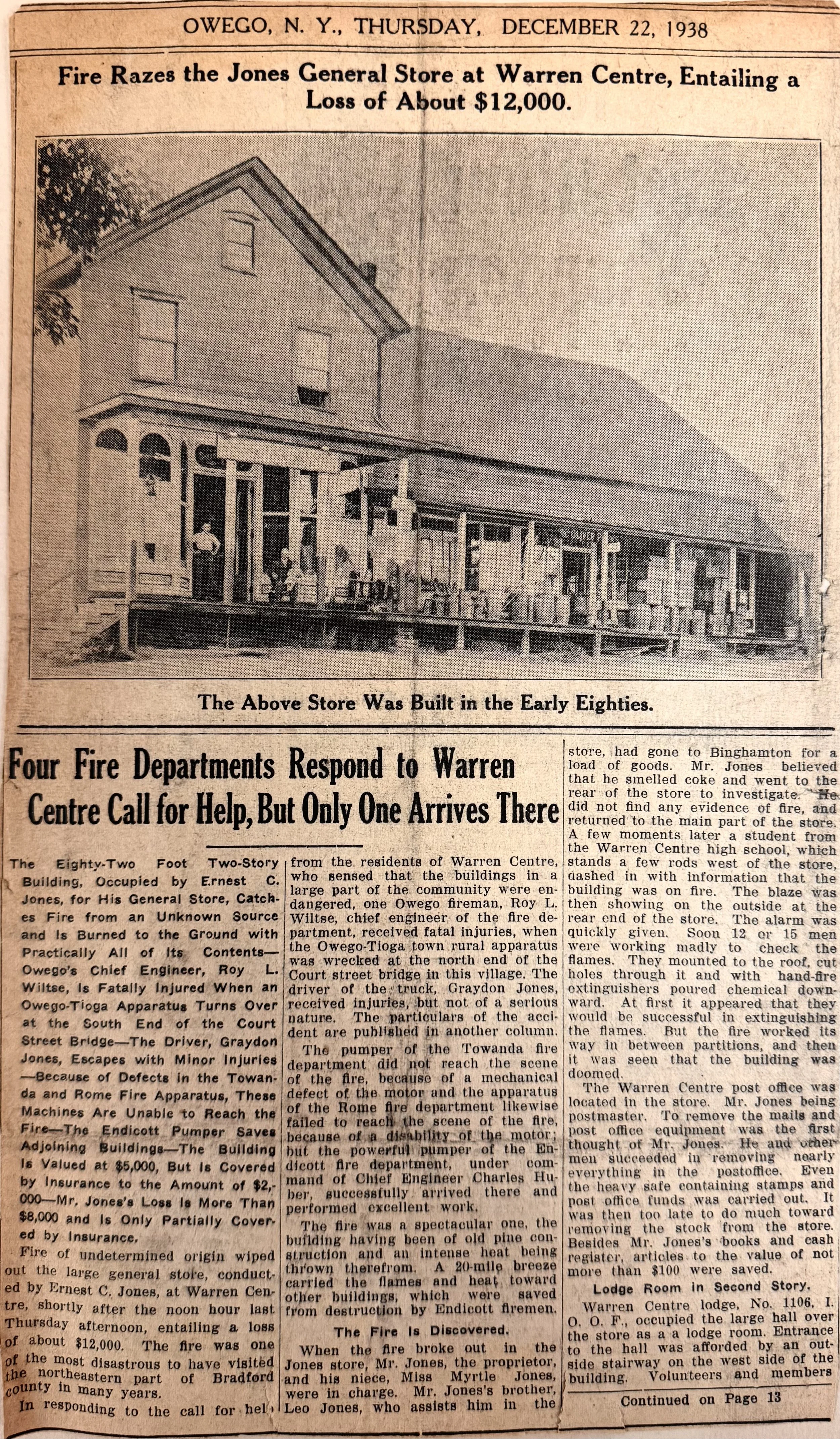 A newspaper article from December 22, 1938, reporting a fire at the Jones General Store at Warren Centre, causing an estimated loss of about $12,000. The article includes a photograph of the two-story building with a porch and several people standing on it.