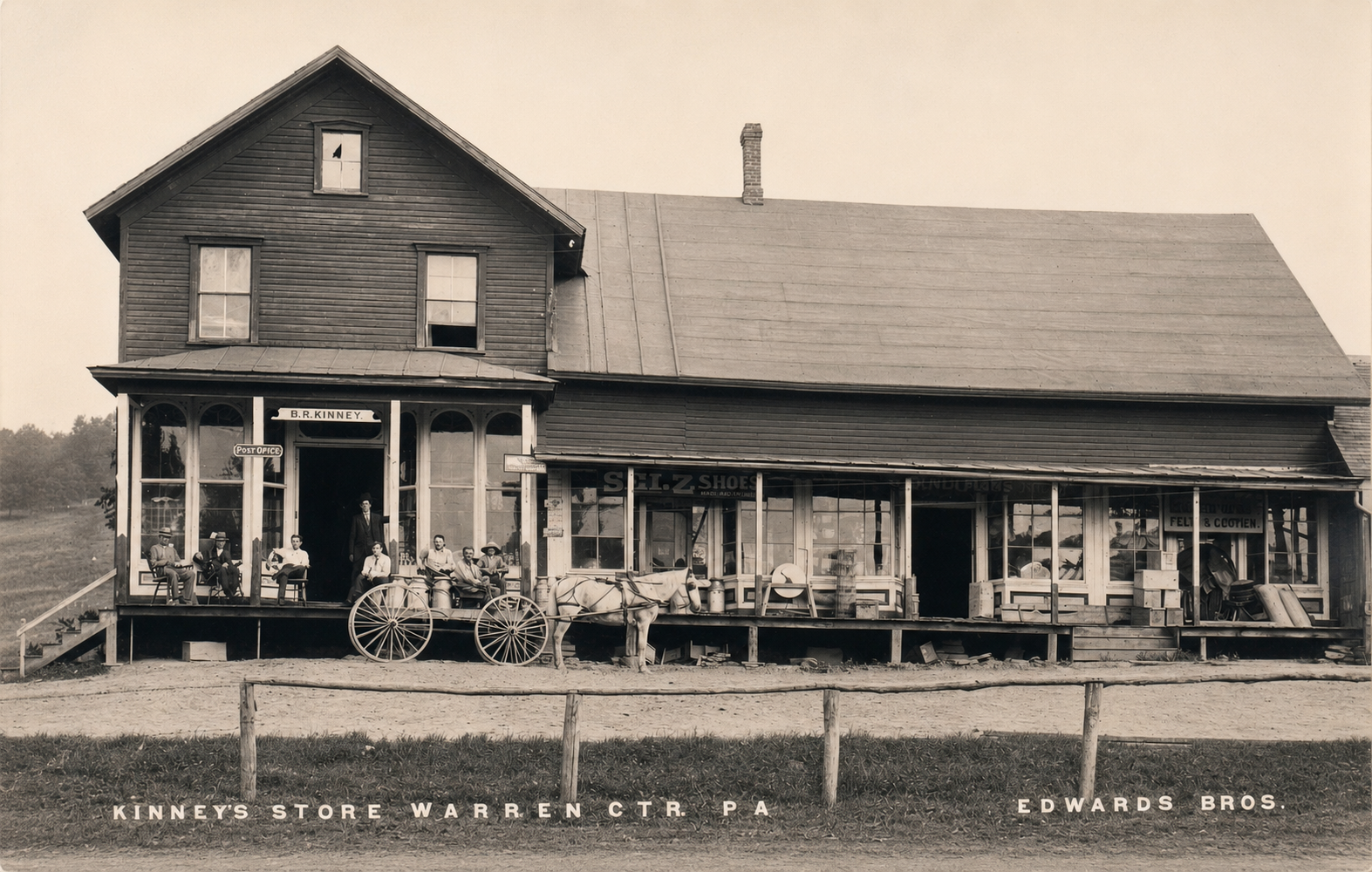 Black and white photo of a two-story wooden store with a porch and a sign that reads 'B. R. Kinney'. Several men are sitting on chairs on the porch, and a man is standing in the doorway. A horse is hitched to the porch, and the store appears to sell shoes and other goods. The store is located in Warren, Pennsylvania, as indicated by the text at the bottom of the image.