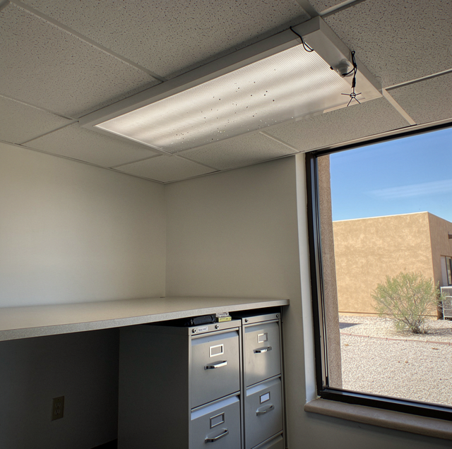 overhead fluorescent lights humming in dark office ceiling