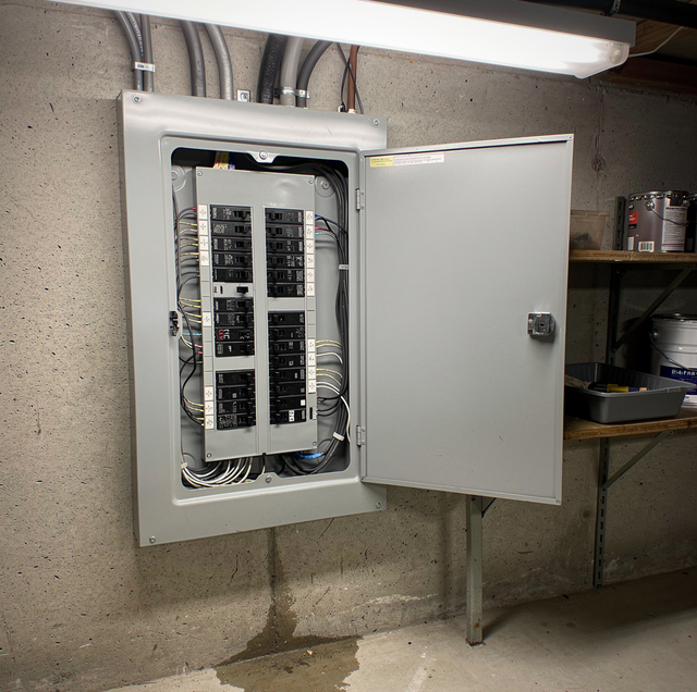 residential electrician wiring a home breaker panel