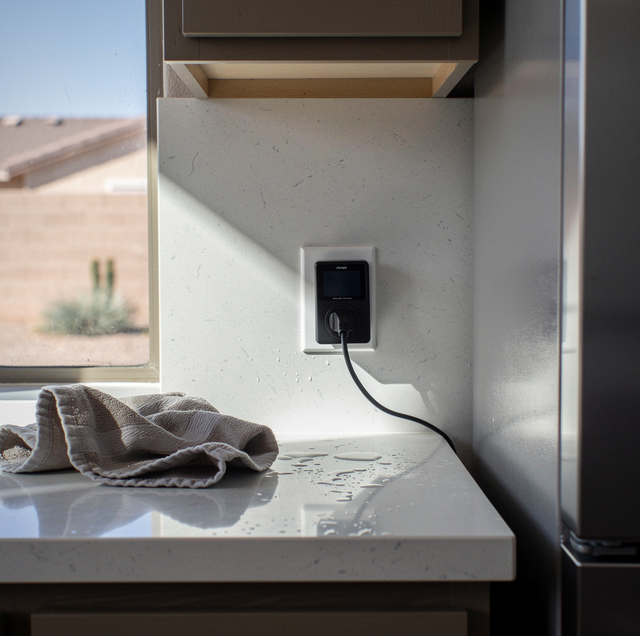 TrickleStar energy monitor plugged into living room wall outlet