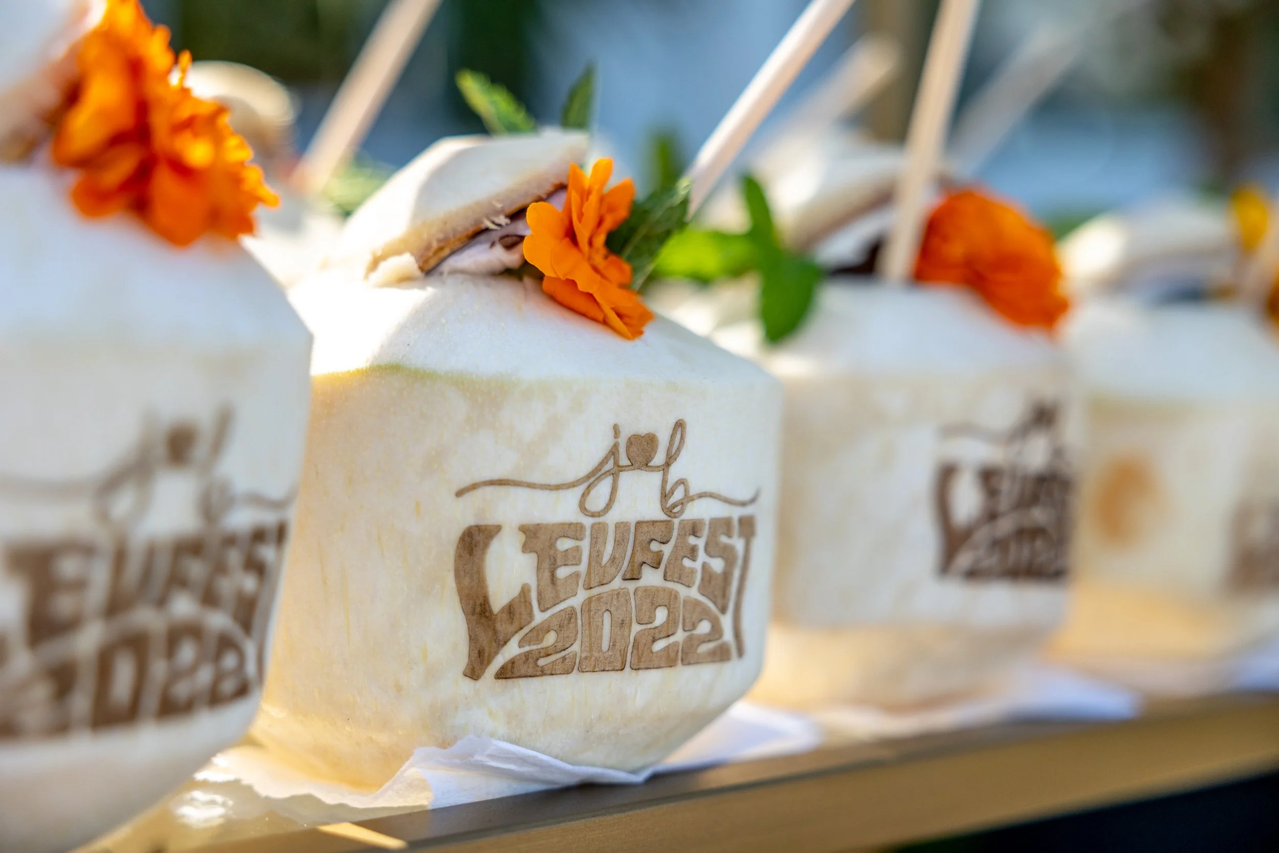 A row of white bars of soap decorated with orange flowers and green leaves, with printed text on the soap indicating love and happiness.