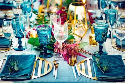 Elegant table setting with colorful glasses, flowers, and decorative items for a celebration or special event.