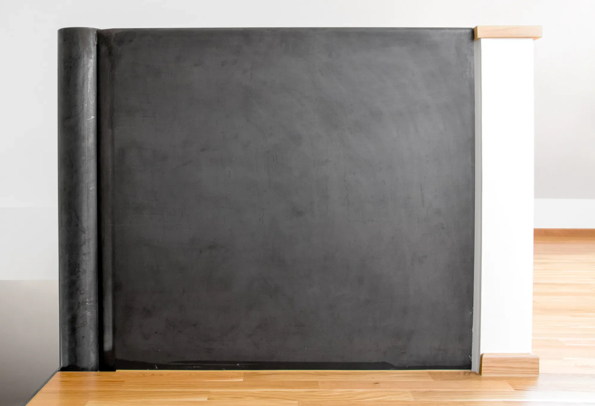 Der Bild zeigt eine schwarze Schultafel an einer Wand entlang auf einer Holzfußboden, mit einem Holzrahmen an der oberen Kante.