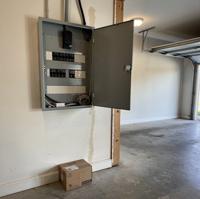 Electric vehicle charger installed beside residential electrical panel