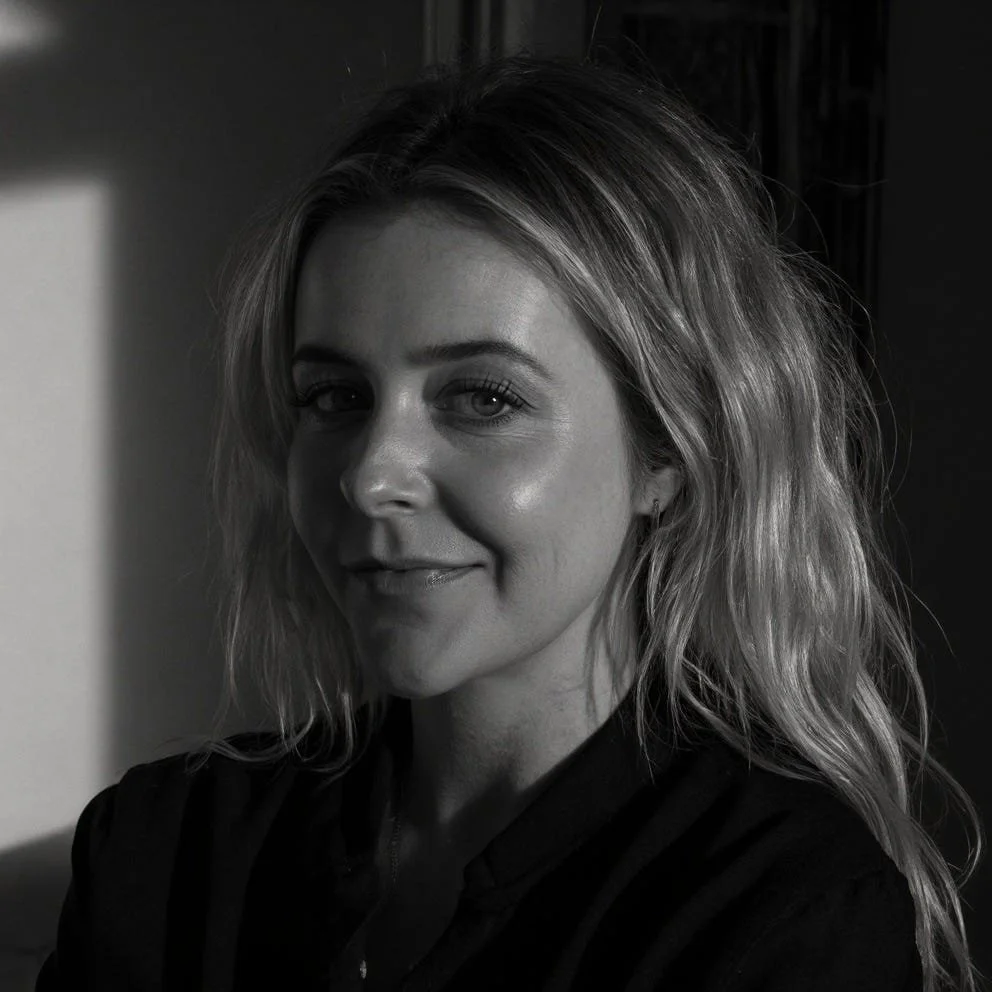 Black and white portrait of a woman with wavy hair smiling at the camera
