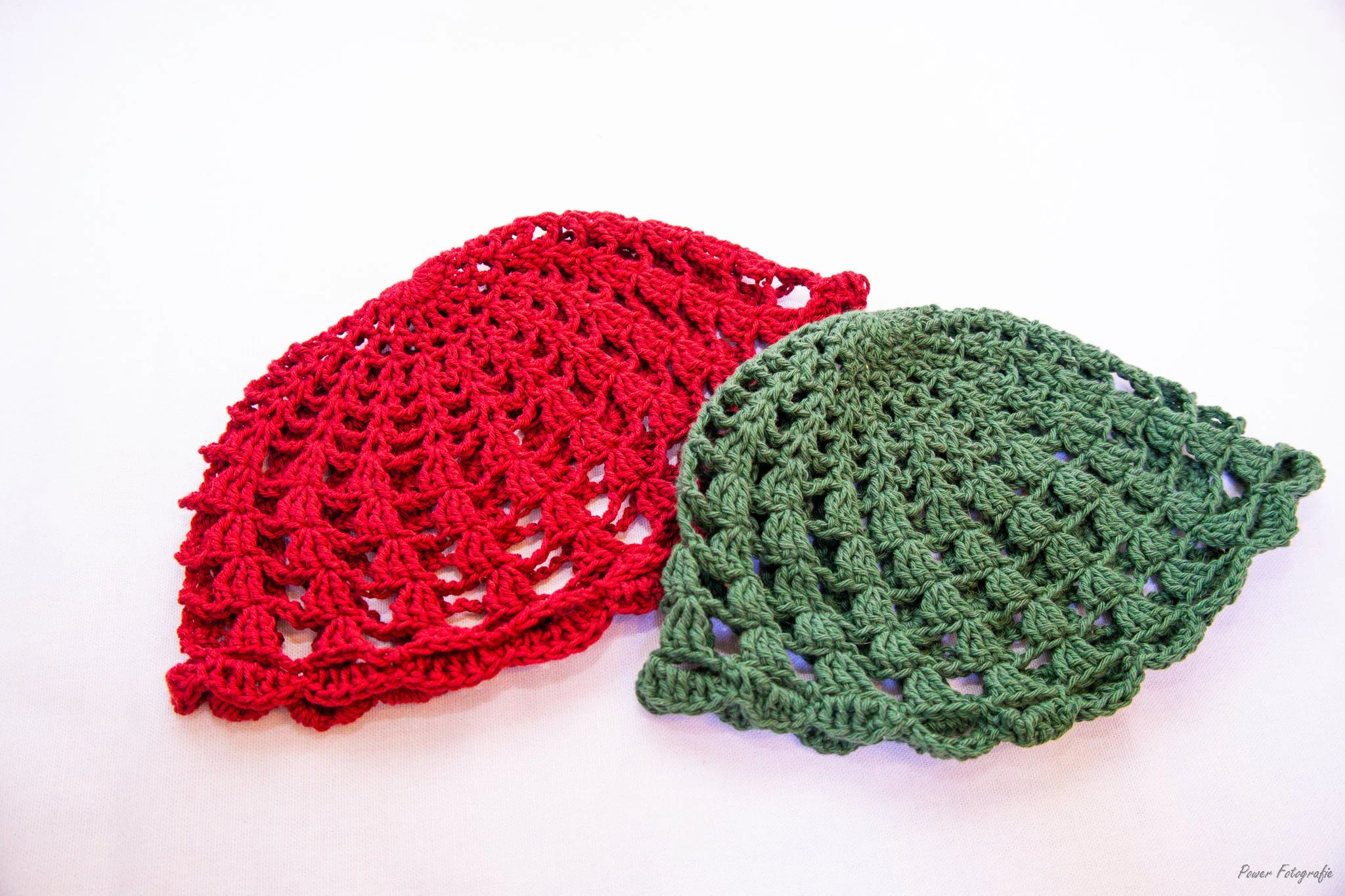 Two crocheted doilies, one red and one green, displayed overlayed on a white background.
