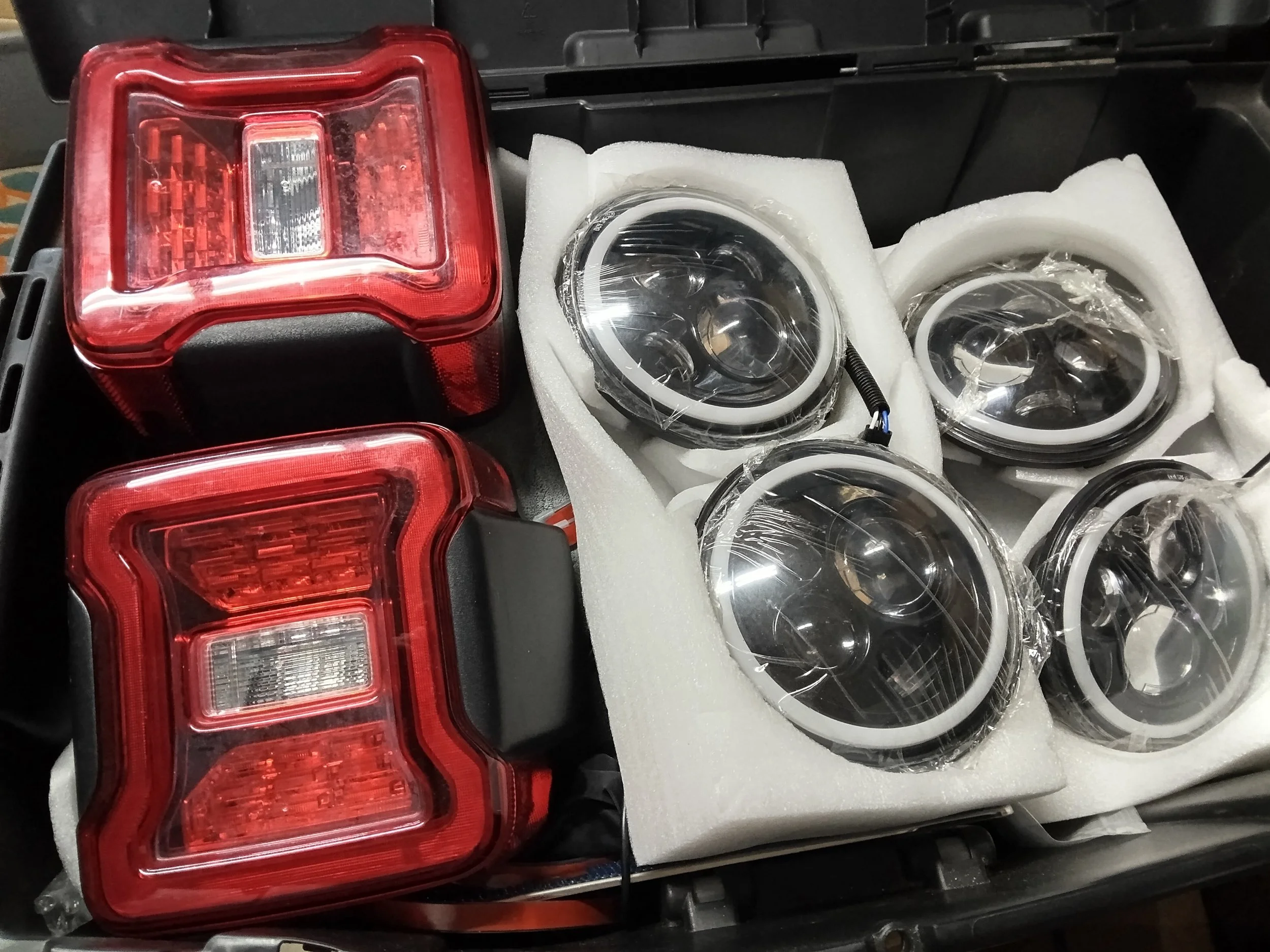 Set of car taillights and headlights packed in foam for transportation.