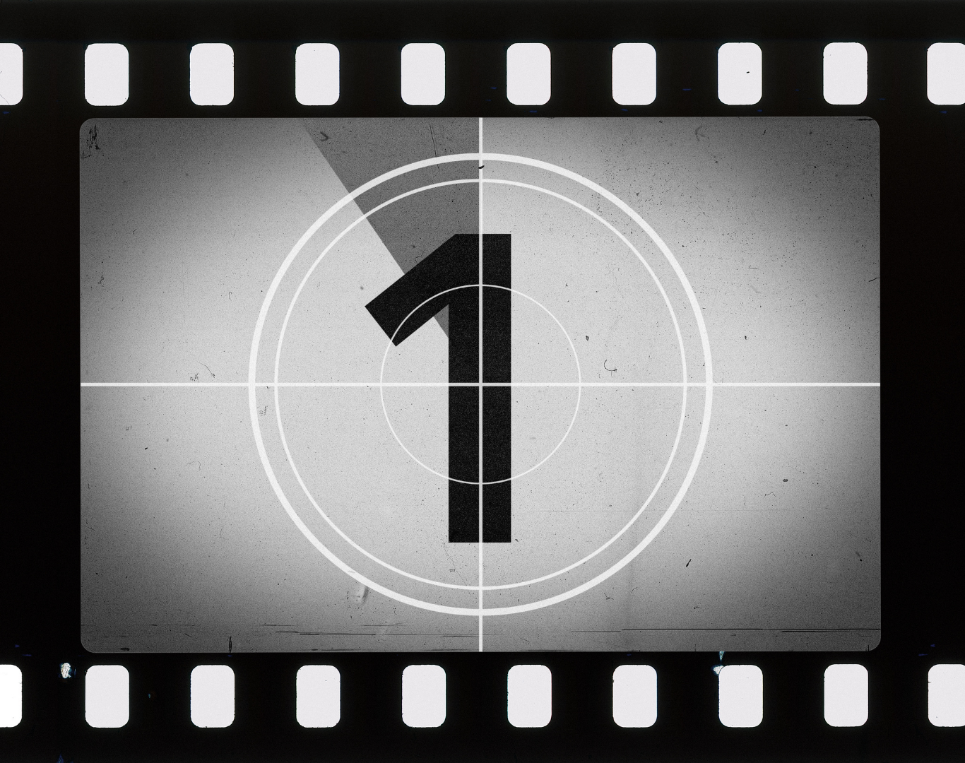 Black and white film countdown with number 1 in the center, surrounded by concentric circles, and sprocket holes at the top and bottom.