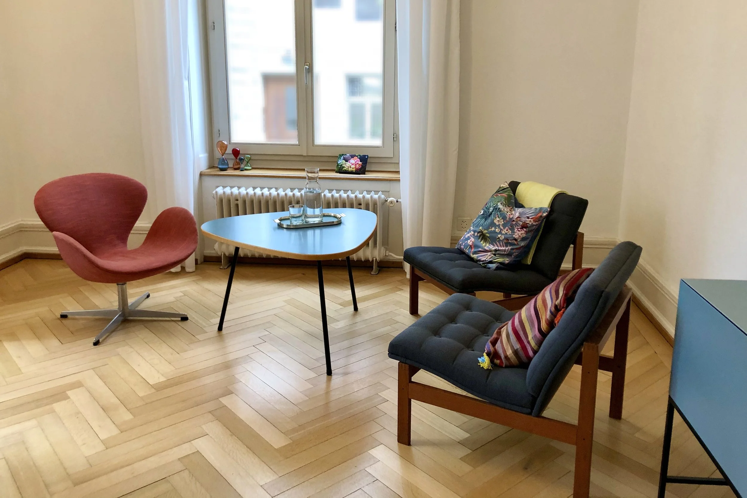 Heller Beratungsraum, drei bequeme Sessel und Nierentisch