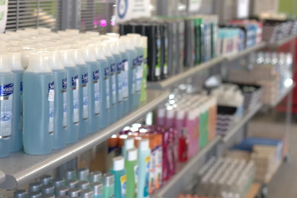 Shelves stocked with various bottles, cans, and boxes of personal care and hygiene products in a store.
