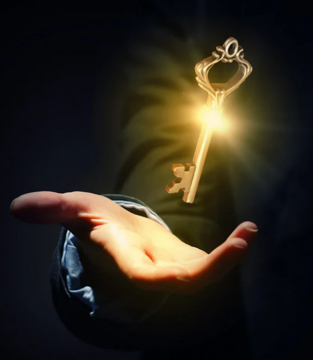 A hand holding out with a glowing, floating gold key above it, illuminated by a bright light source.