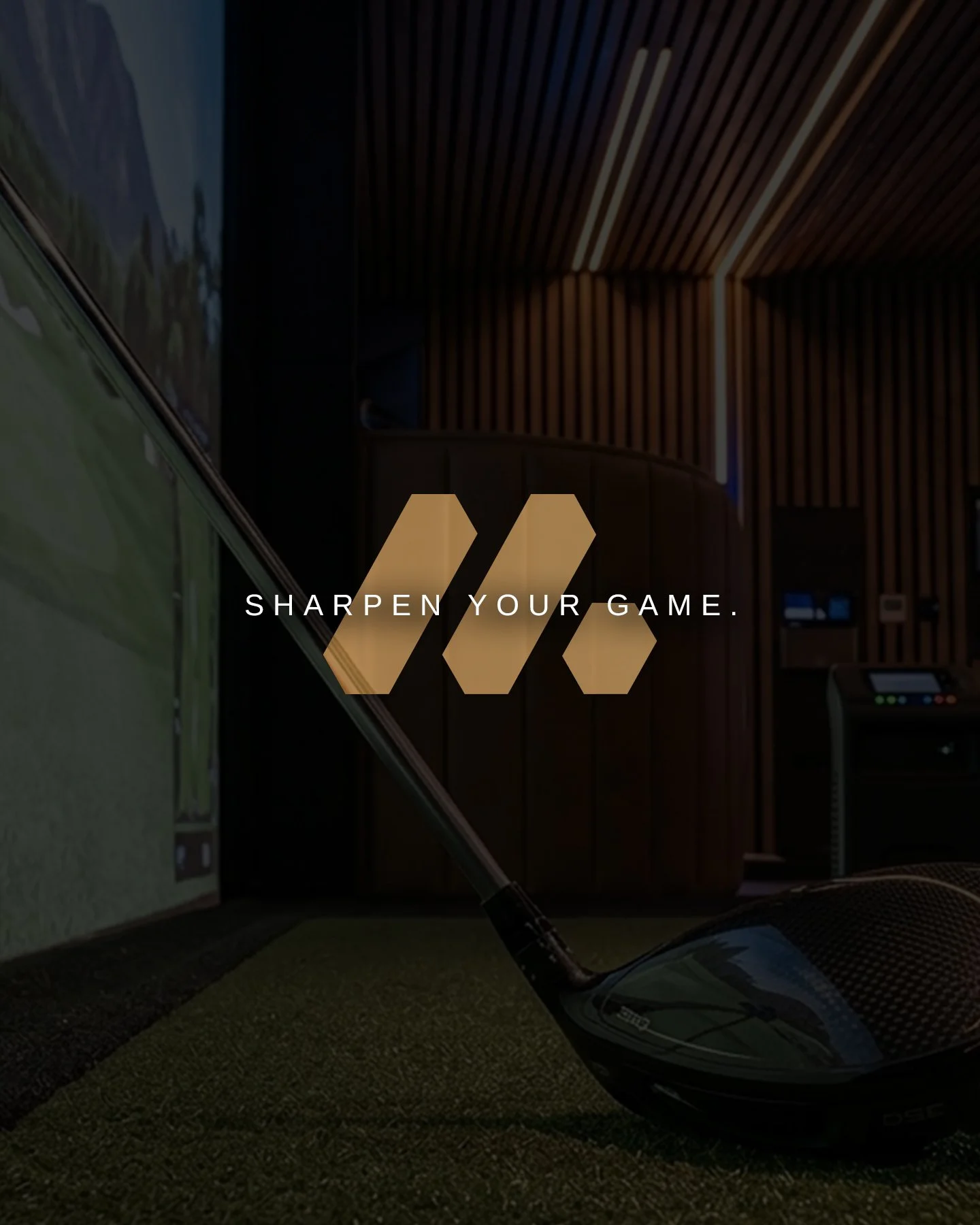 Indoor golf simulator room with wooden panel walls, a golf club, and a golf simulator screen displaying a golf course.
