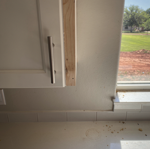 white kitchen cabinet filler strip beside wall panel