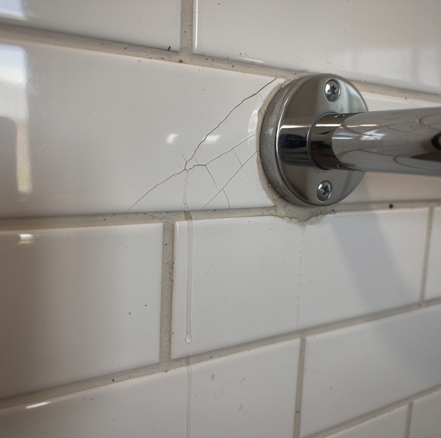 Chrome grab bar mounted on tiled bathroom wall