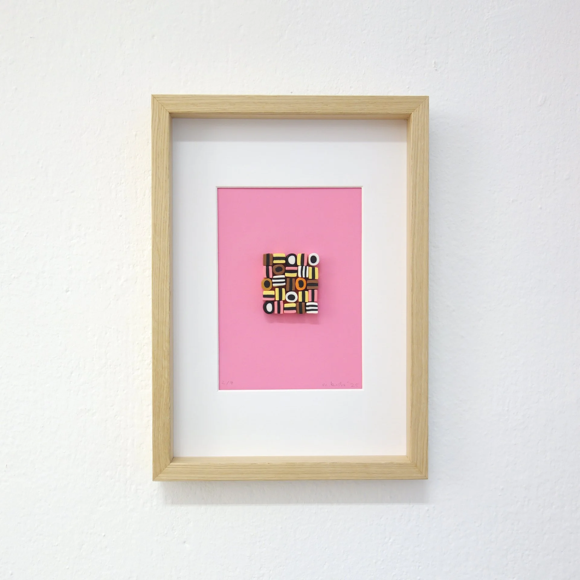 Framed Kunstwerk mit pinkem Hintergrund und schwarzen, weißen, gelben geometrischen Formen.