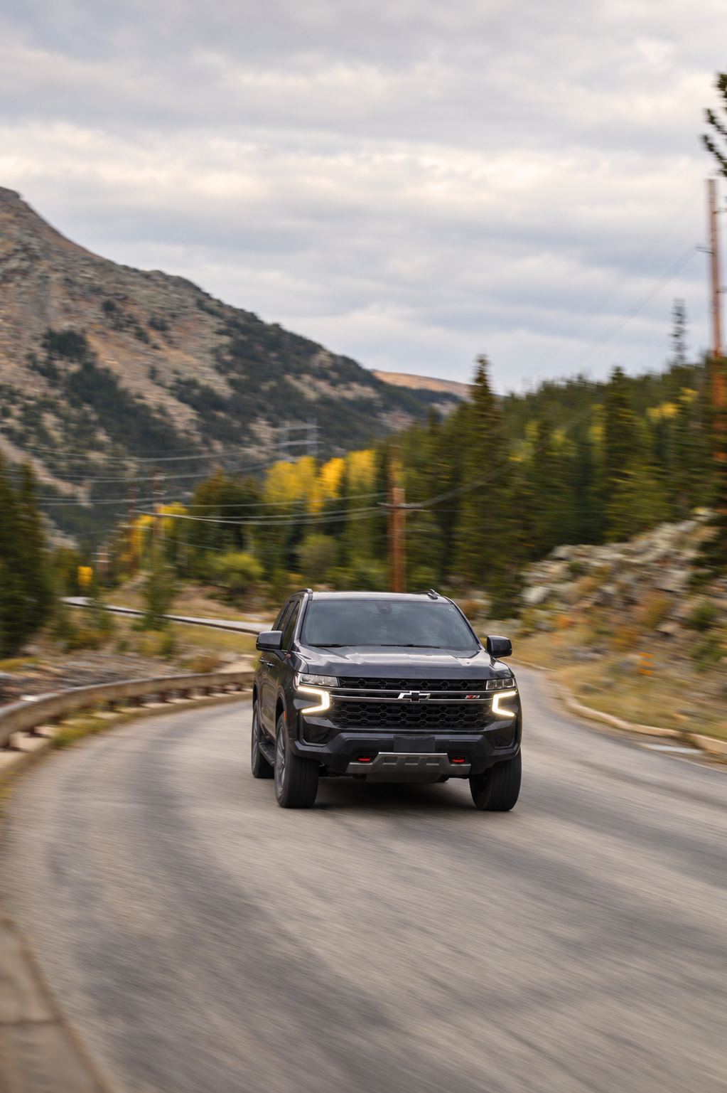 Driving through winding mountain road with trees and hills in the Rocky Mountains, Colorado.