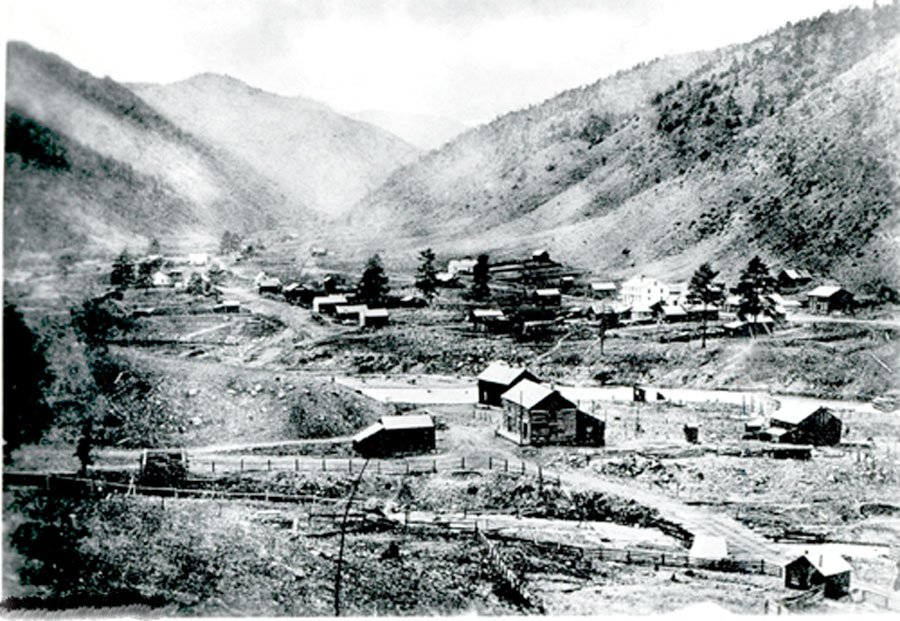 A black and white photo of a small, rural mountain town in the Rocky Mountains, Colorado.