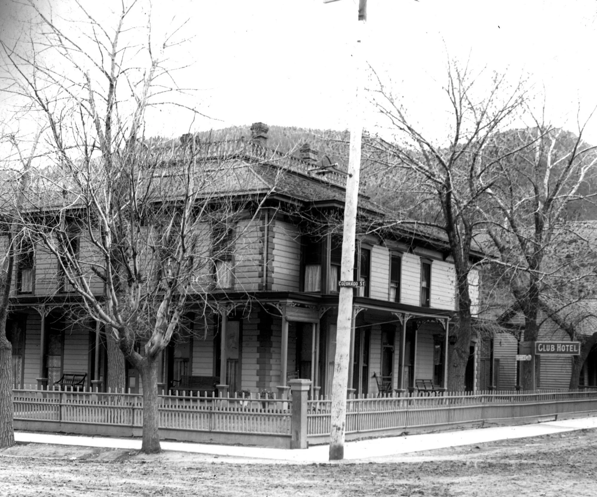 'Colorado St.' and another sign says 'Club Hotel' near Rocky Mountains, Colorado.