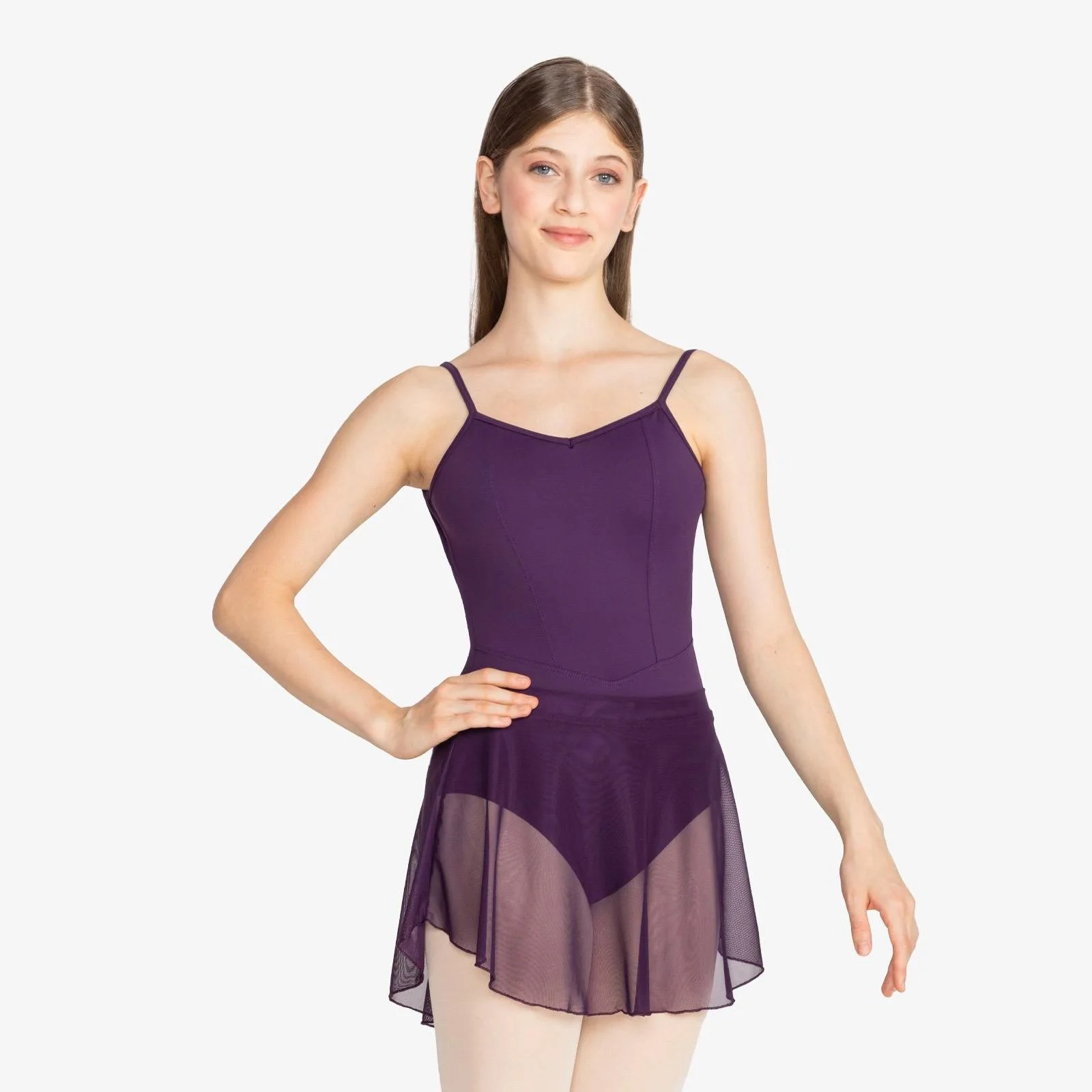 A young woman in a purple ballet leotard and sheer purple skirt standing with one hand on her hip, against a white background.